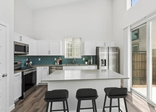 a kitchen with an island and three bar stools at Baseline on 16, Arizona