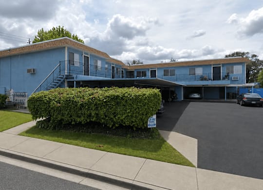 A blue building with a parking lot in front.
