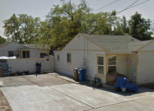 a small white house with a yard in front of it