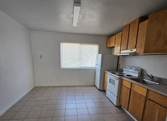 an empty kitchen with a stove refrigerator and sink