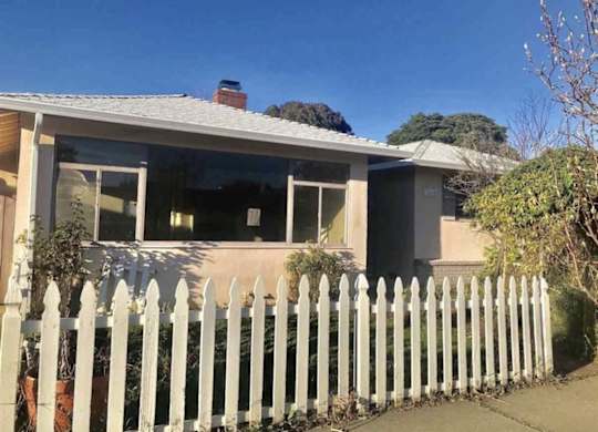 a house with a white fence in front of it
