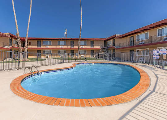 a resort style swimming pool in front of a hotel