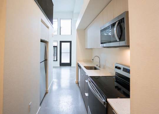 A modern kitchen with black appliances and white countertops.