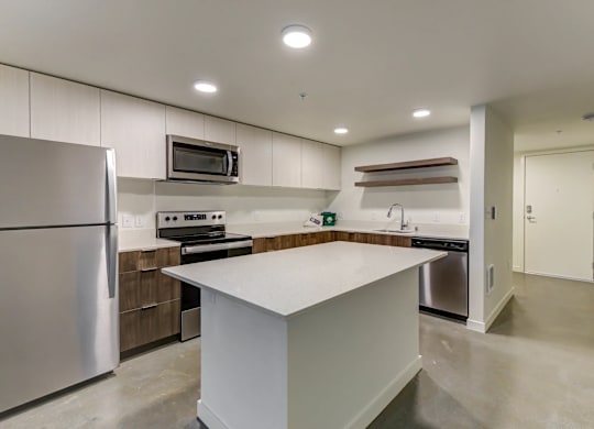 A modern kitchen with a refrigerator, stove, and oven.