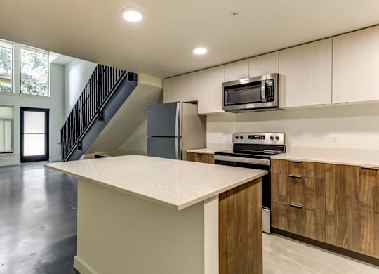 A kitchen with a white counter top and wooden cabinets.