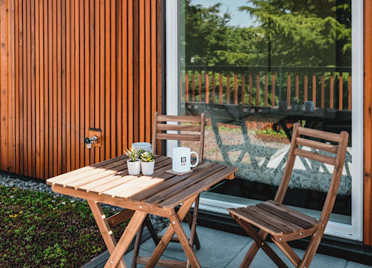 A wooden table with two chairs and a cup on it.