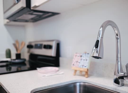 A kitchen sink with a chrome faucet and a small wooden stand with cards on it.