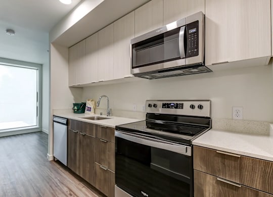 A kitchen with a black oven and microwave above it.
