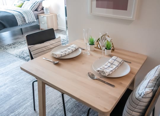 a dining room with a wooden table with plates and utensils on it