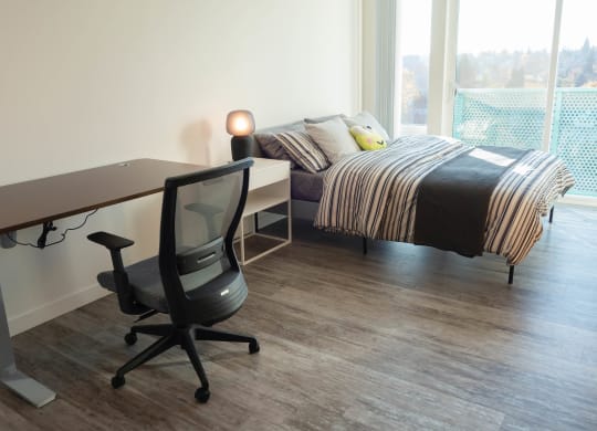 a bedroom with a bed and a desk and a chair