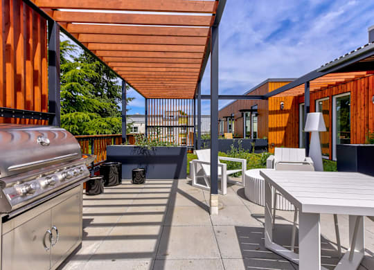 A patio with a grill and a table.