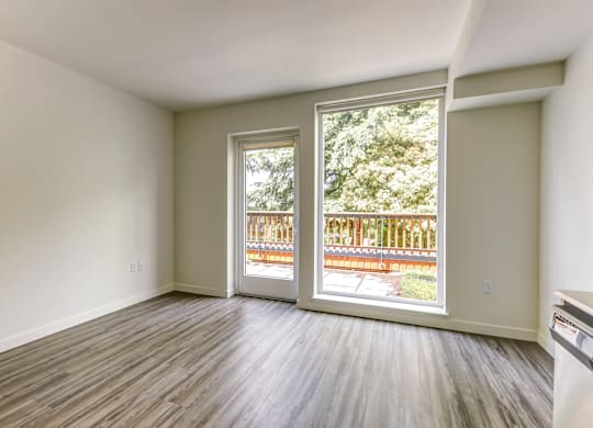 A room with a large window and a wooden floor.