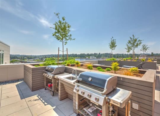 a barbecue grill on a patio with a view of the city