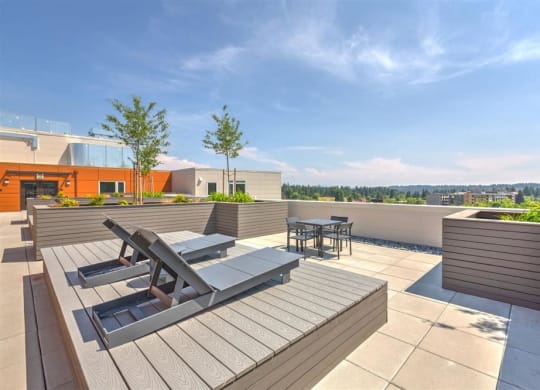a roof top patio with a table and chairs