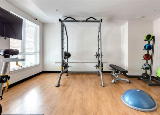 a home gym with exercise equipment and a tv