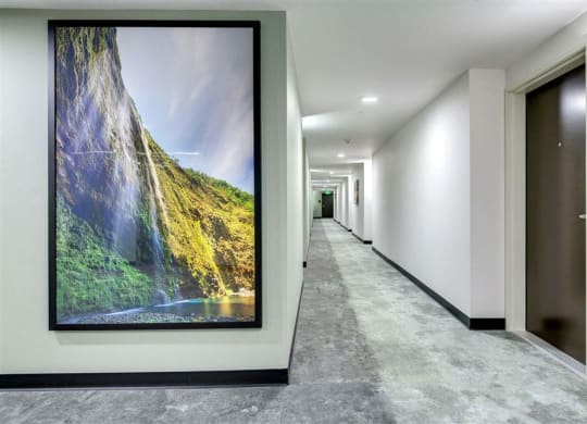 a large painting hangs on a wall in a hallway