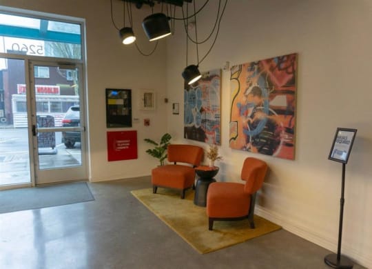 a lobby with chairs and paintings on the wall