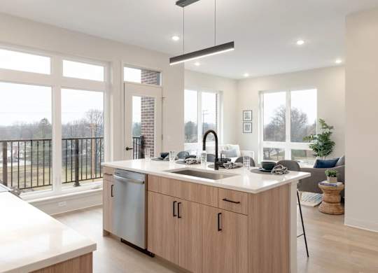 A modern kitchen with wooden cabinets and a large window.