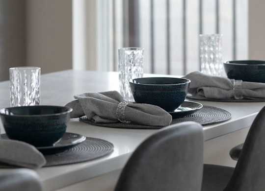 A table set for two with a view of a balcony.