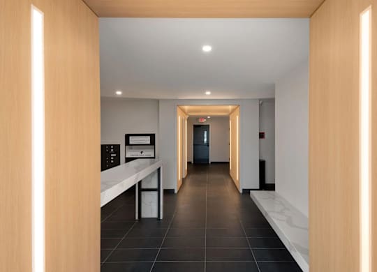A hallway with a white counter and a black floor.