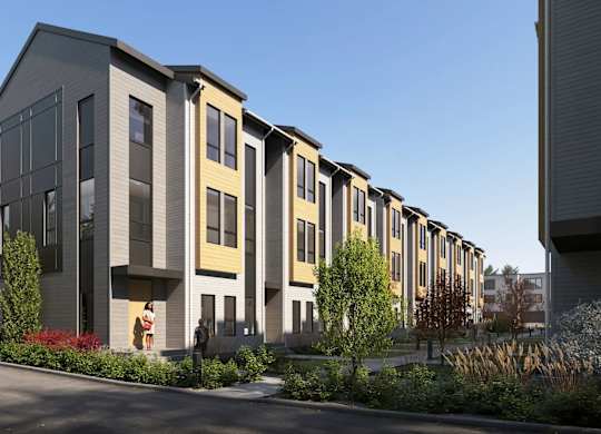 A row of modern townhouses with a clear blue sky above.