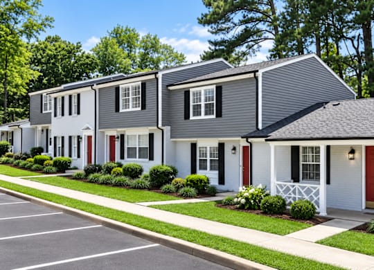 A row of houses with red doors and white trim.