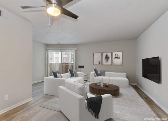 a living room with white couches and a tv  at Eastwood Crossings, Kansas City, MO