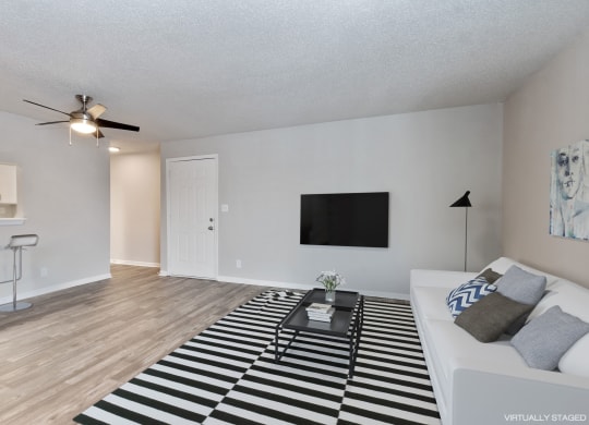 an open living room with a white couch and a black and white rug  at Eastwood Crossings, Kansas City, 64129