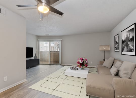 a living room with a couch and a ceiling fan  at Eastwood Crossings, Kansas City, Missouri