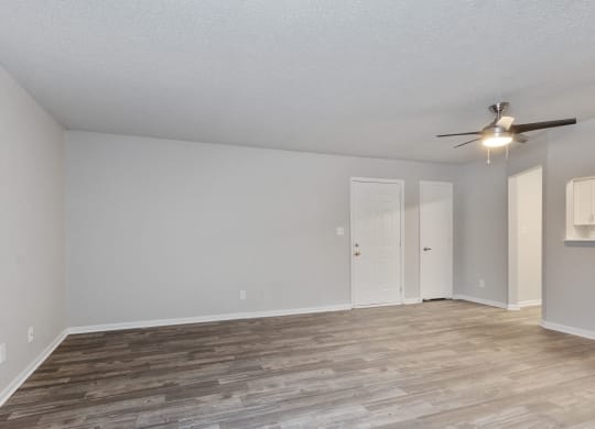the spacious living room with wood flooring and a ceiling fan  at Eastwood Crossings, Kansas City, MO, 64129
