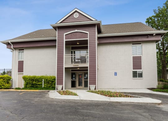 the front of a building with a balcony and a parking lot at Eastwood Crossings, Kansas City, 64129