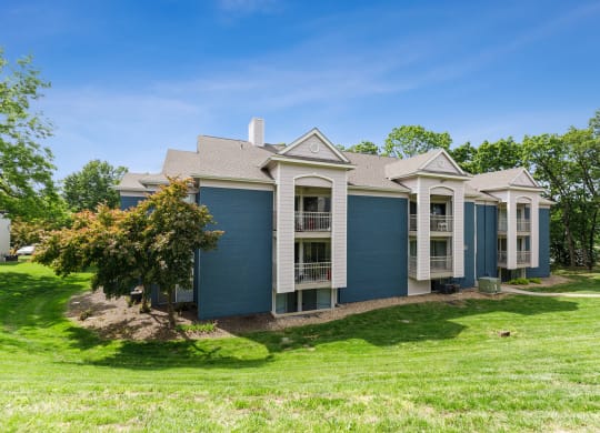 a blue house with white trim and a green lawn at Eastwood Crossings, Missouri, 64129
