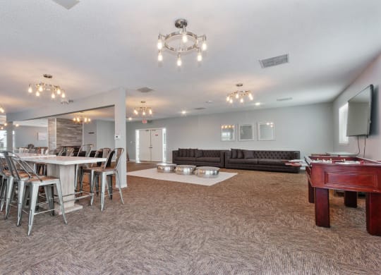 a game room with a pool table and a bar with chairs at Eastwood Crossings, Kansas City, MO, 64129