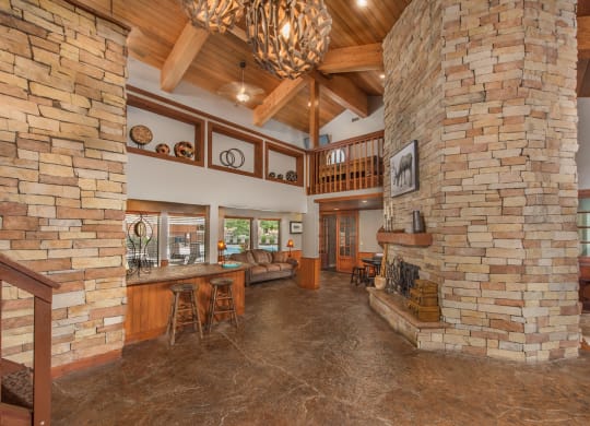 a large living room with a fireplace and a kitchen at Lodge of Overland Park Apartments, Overland Park , Kansas