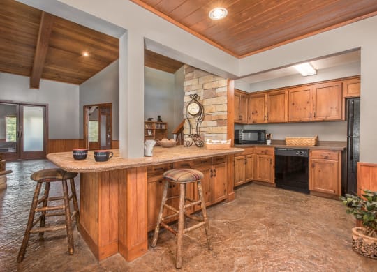 a large kitchen with a large island with bar stools at Lodge of Overland Park Apartments, Kansas