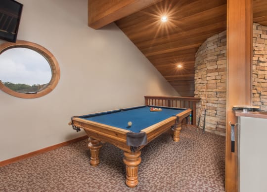 a pool table in a cabin with a porthole at Lodge of Overland Park Apartments, Kansas