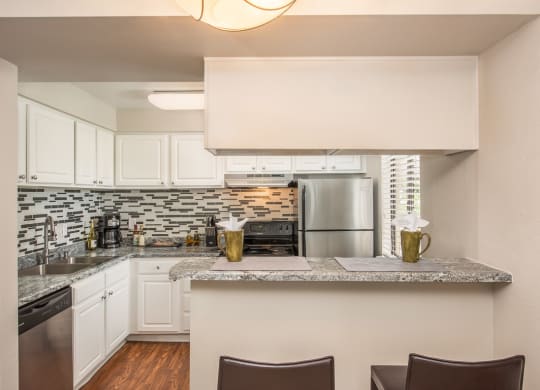 a kitchen with white cabinets and a granite counter top at Lodge of Overland Park Apartments, Kansas, 66212