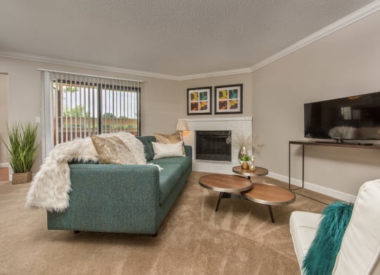 a living room with a blue couch and a fireplace at Lodge of Overland Park Apartments, Overland Park , 66212