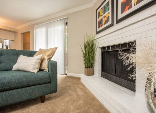 a living room with a fireplace and a green couch at Lodge of Overland Park Apartments, Kansas, 66212