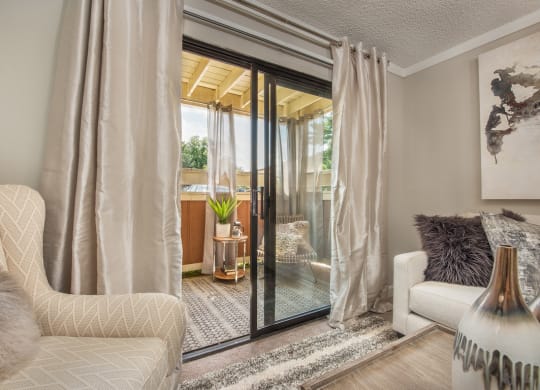 a living room with a sliding glass door to a patio at Lodge of Overland Park Apartments, Overland Park