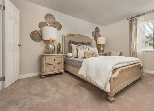 a bedroom with a bed and lamps and a window at Lodge of Overland Park Apartments, Overland Park , KS 66212