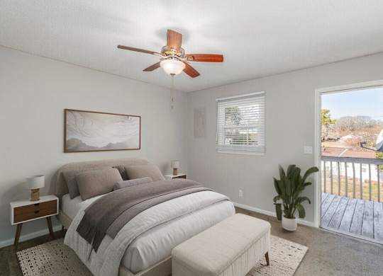 A bedroom with a bed, a bench, a ceiling fan, and a window with blinds.