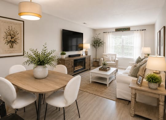 A living room with a white couch, a wooden table, and a television.