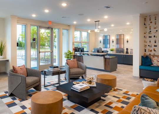 A modern living room with a large window and a view of the street at Hudson at Renaissance Apartments, North Carolina