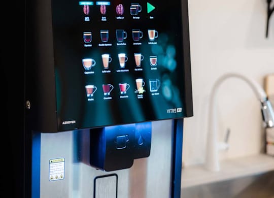 A black vending machine with a digital display and a variety of drink options at Hudson at Renaissance Apartments, Wilmington, NC 28405