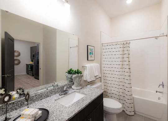 A bathroom with a white shower curtain at Hudson at Renaissance Apartments, Wilmington, NC 28405