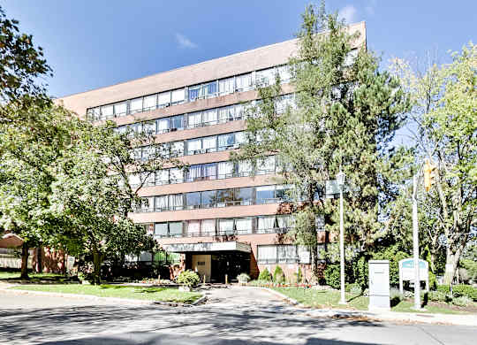 A large building with a lot of windows and trees in front.