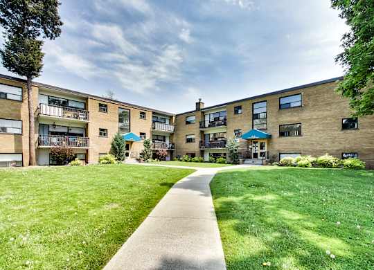 A grassy area in front of apartment buildings.