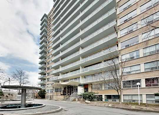 A tall residential building with a pool in front.