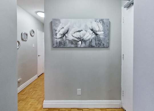 the living room of a house with a painting on the wall